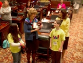 Fifth graders Devynne Valentin and Broderic Shipe present a plaque to Sen. Judy Schwank.